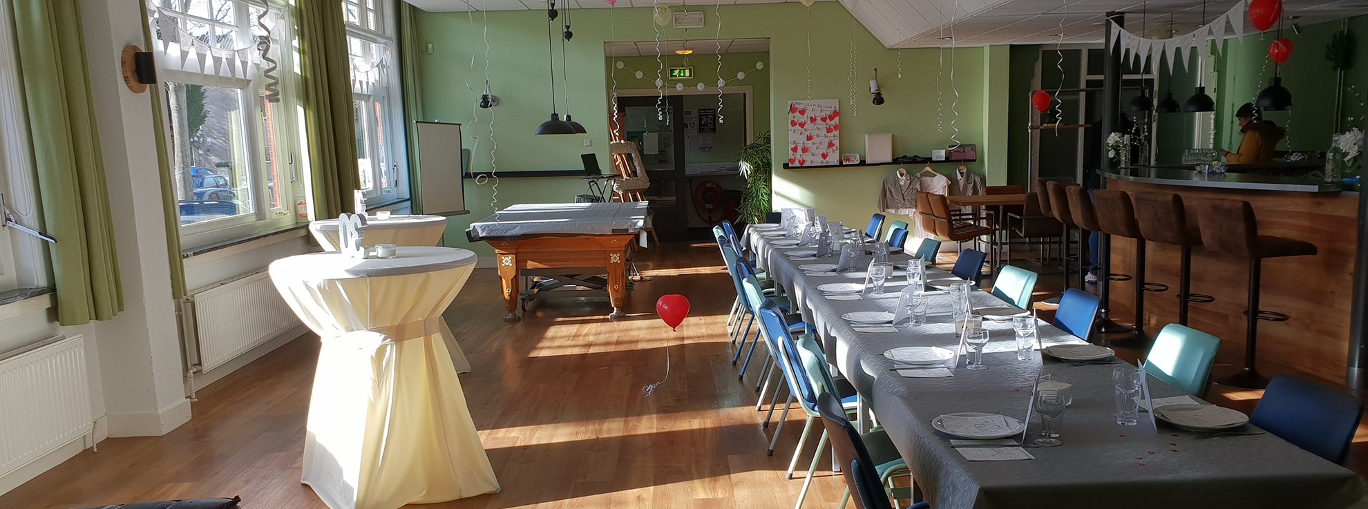 de grote zaal van de Molenwerf, versierd voor een feest met ballonnen en slingers